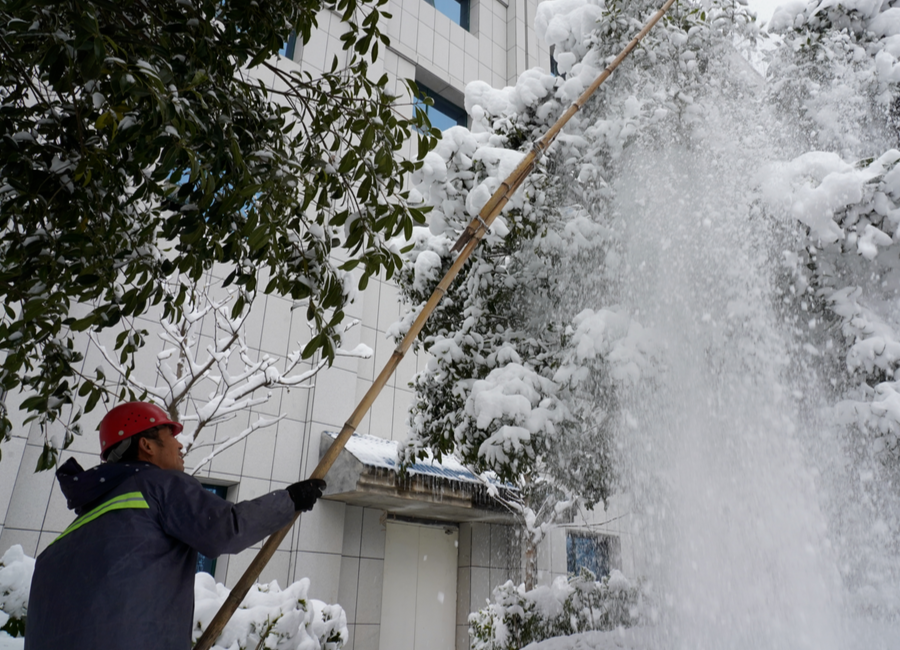 中方：园林绿化工人冒雪清理压断树枝